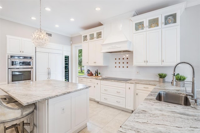 kitchen featuring premium range hood, white cabinetry, and stainless steel double oven