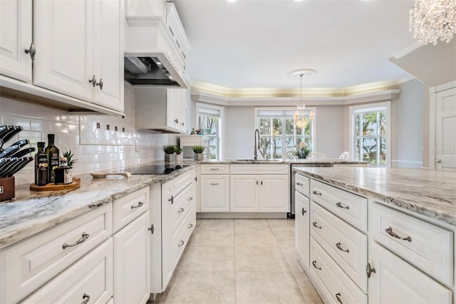 kitchen with a chandelier, black electric cooktop, decorative light fixtures, custom exhaust hood, and white cabinetry