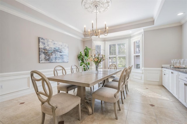 dining space featuring crown molding, an inviting chandelier, light tile patterned floors, and a tray ceiling