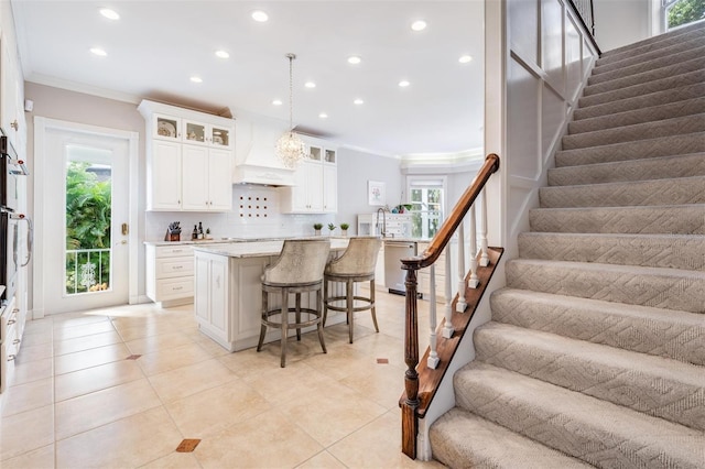 kitchen featuring plenty of natural light, hanging light fixtures, a kitchen island, and a breakfast bar