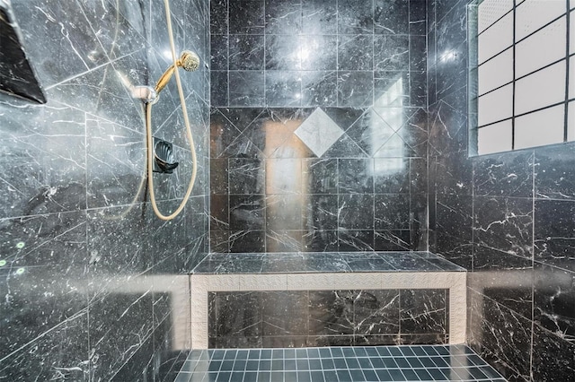 bathroom featuring tiled shower and tile walls