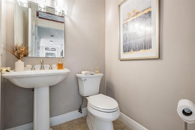 bathroom featuring sink, tile patterned flooring, and toilet