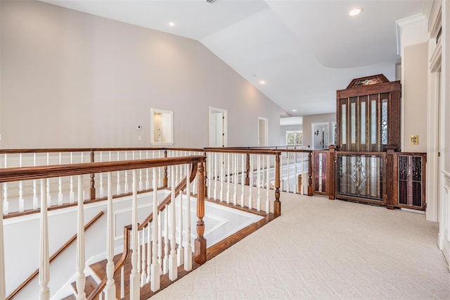 hallway featuring light carpet and vaulted ceiling