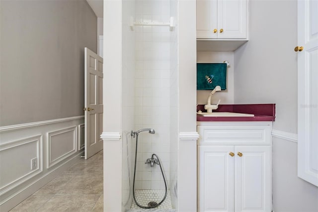 bathroom with vanity, tile patterned flooring, and tiled shower