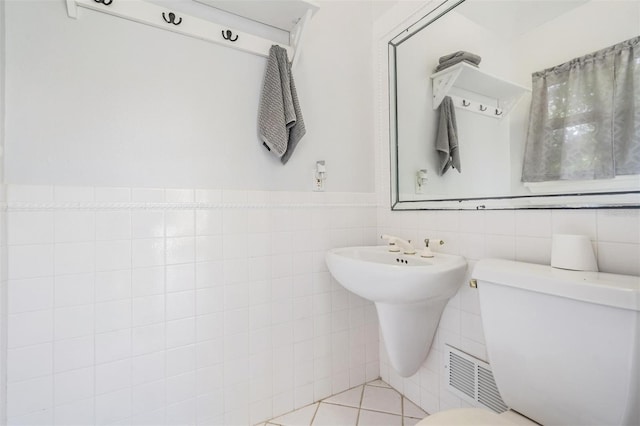 bathroom featuring tile patterned floors, tile walls, and toilet