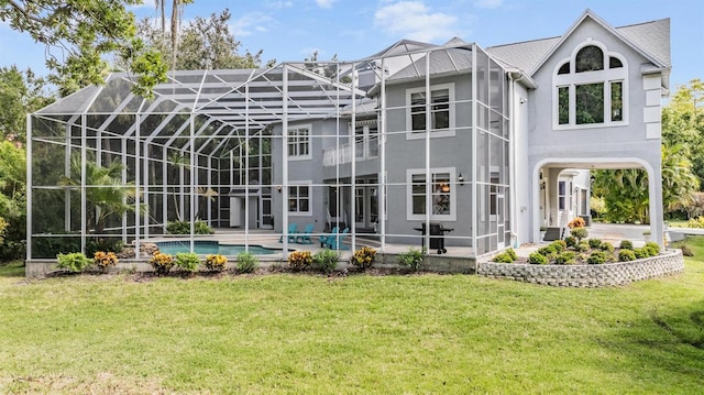 back of house with a patio, a lawn, and a lanai