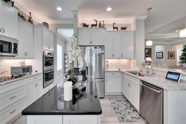 kitchen with a sink, tasteful backsplash, appliances with stainless steel finishes, a peninsula, and a toaster