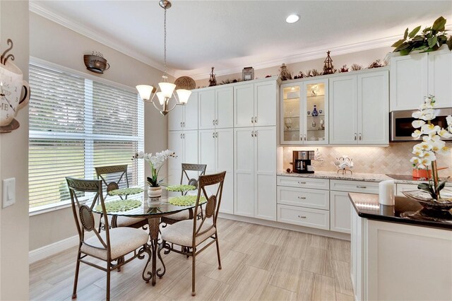 dining space with crown molding and a notable chandelier