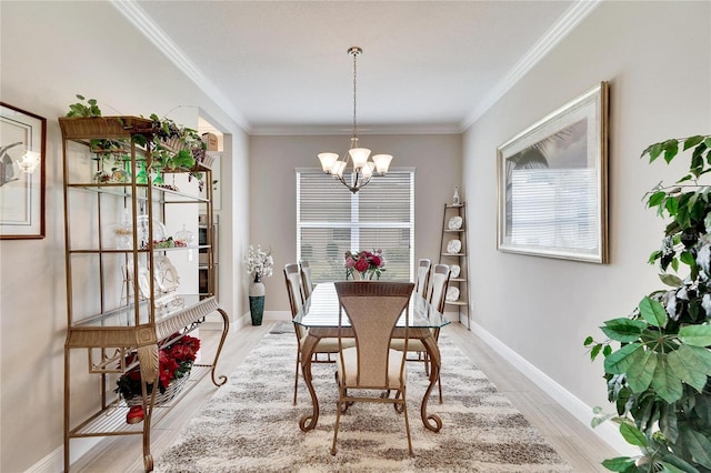 dining room featuring crown molding, light hardwood / wood-style flooring, and an inviting chandelier