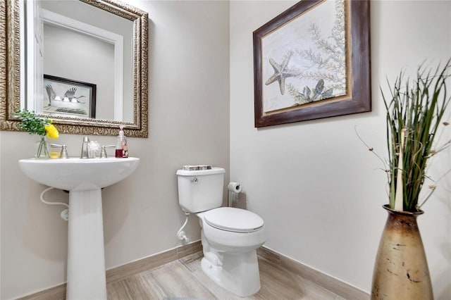 bathroom with hardwood / wood-style floors and toilet