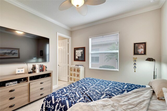 bedroom featuring light carpet, ornamental molding, and ceiling fan