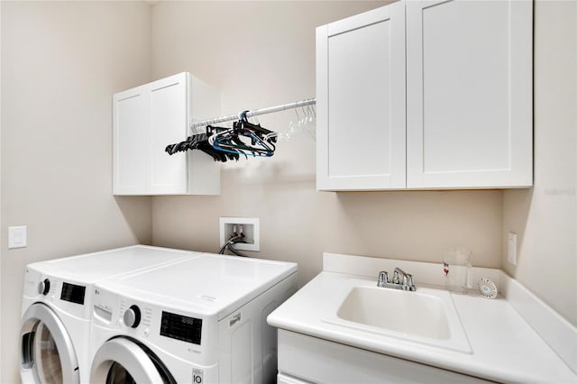 washroom featuring washing machine and clothes dryer, cabinets, and sink