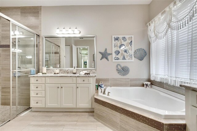 bathroom featuring vanity and independent shower and bath