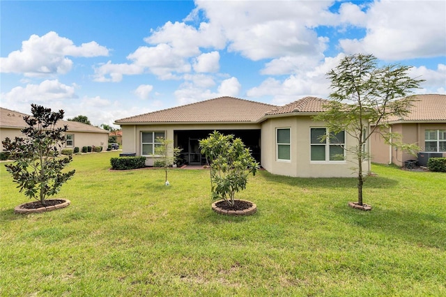 back of house featuring stucco siding, central AC unit, a tiled roof, and a yard
