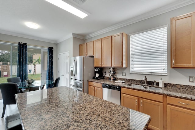 kitchen featuring appliances with stainless steel finishes, stone counters, sink, and a kitchen island