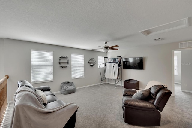 living room featuring ceiling fan, carpet floors, and a textured ceiling