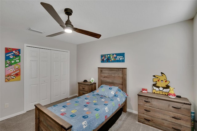 carpeted bedroom with ceiling fan and a closet