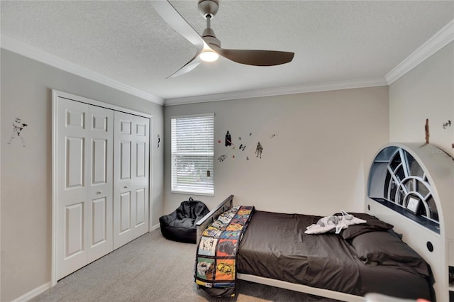 carpeted bedroom with ceiling fan, a textured ceiling, a closet, and ornamental molding