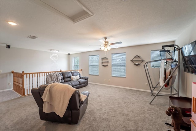 carpeted living room with a textured ceiling and ceiling fan