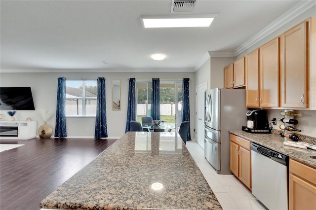 kitchen with light brown cabinets, stainless steel appliances, stone counters, and light hardwood / wood-style flooring