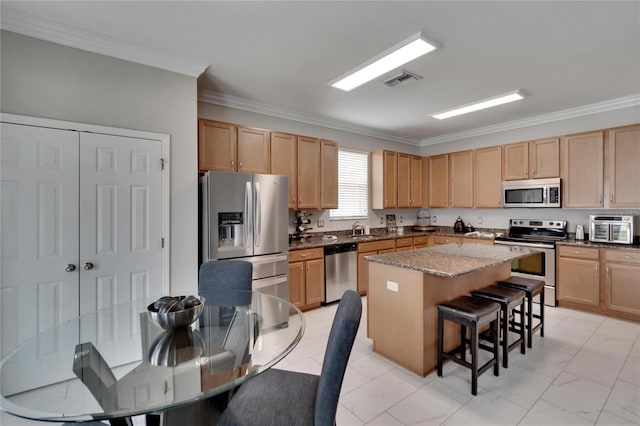 kitchen featuring a center island, light brown cabinets, appliances with stainless steel finishes, and sink