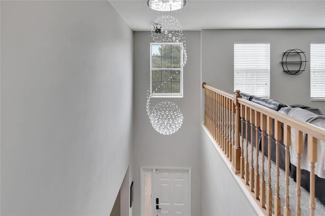 stairway with an inviting chandelier and plenty of natural light