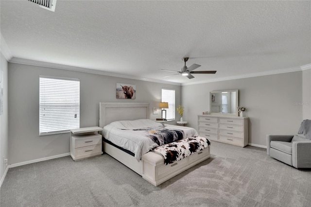 bedroom featuring light carpet, ceiling fan, ornamental molding, and a textured ceiling