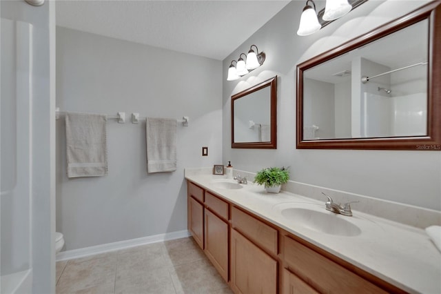 bathroom featuring walk in shower, vanity, toilet, and tile patterned floors