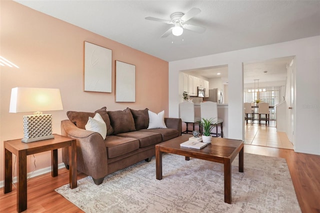 living room featuring ceiling fan and light hardwood / wood-style floors