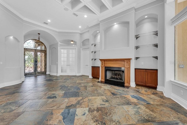 unfurnished living room with built in features, french doors, coffered ceiling, a high ceiling, and crown molding