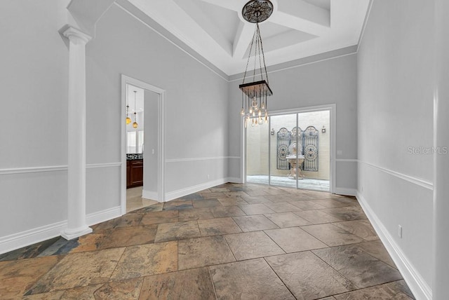 unfurnished dining area featuring a chandelier, crown molding, and ornate columns