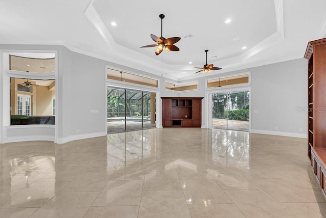 unfurnished living room featuring crown molding, a tray ceiling, and ceiling fan