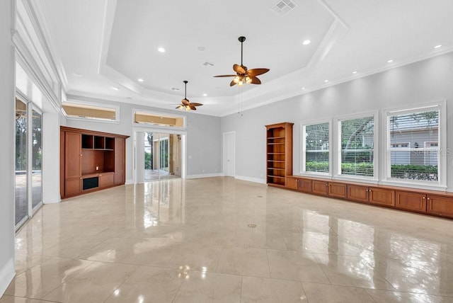 unfurnished living room with a tray ceiling, ceiling fan, and crown molding