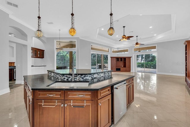 kitchen with ceiling fan, decorative light fixtures, a kitchen island with sink, and a healthy amount of sunlight