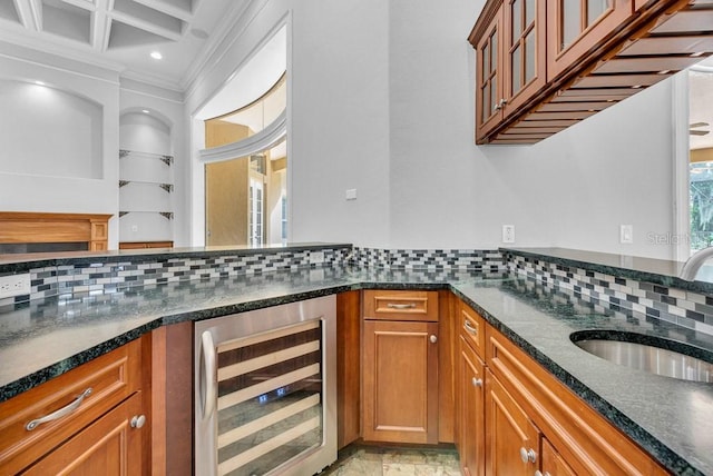 kitchen with decorative backsplash, wine cooler, dark stone counters, and crown molding