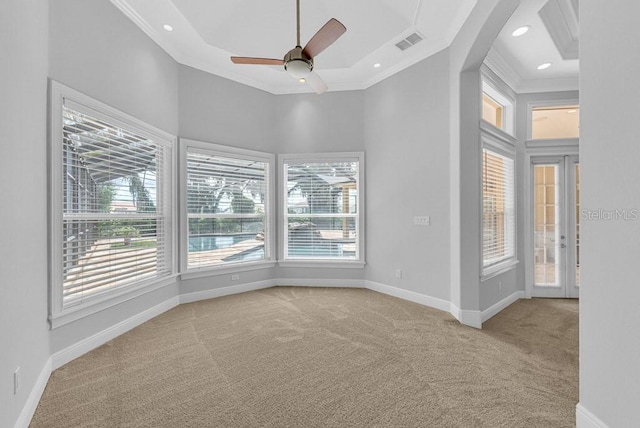 spare room featuring light carpet, a wealth of natural light, ceiling fan, and crown molding