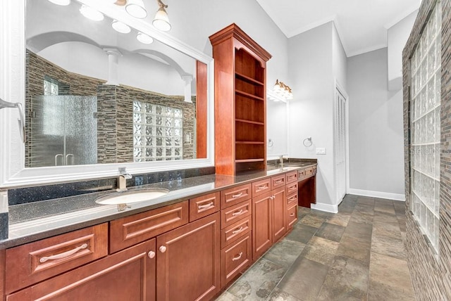 bathroom with ornamental molding, vanity, and a shower with door