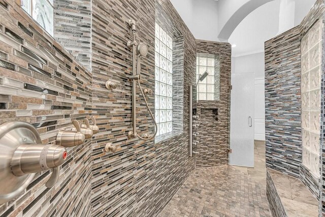 bathroom featuring ornamental molding and a tile shower