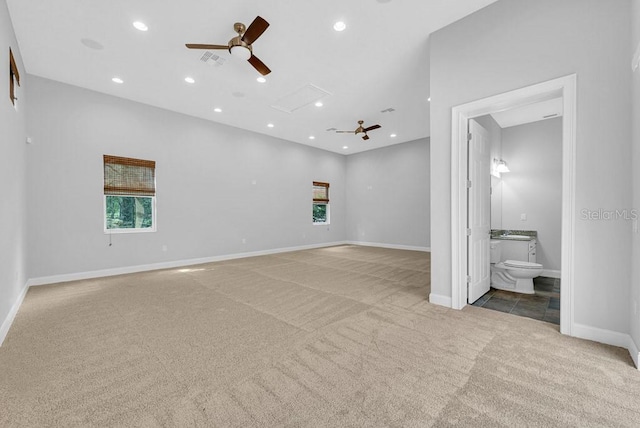 interior space featuring ceiling fan, light carpet, and ensuite bathroom