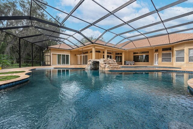 view of pool with ceiling fan, a lanai, and a patio area