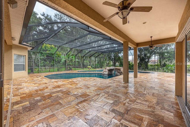 view of swimming pool with glass enclosure, an in ground hot tub, ceiling fan, and a patio area