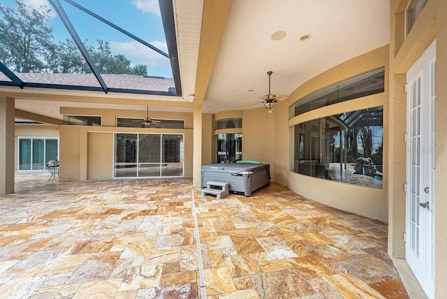 view of patio featuring ceiling fan, a lanai, and a hot tub