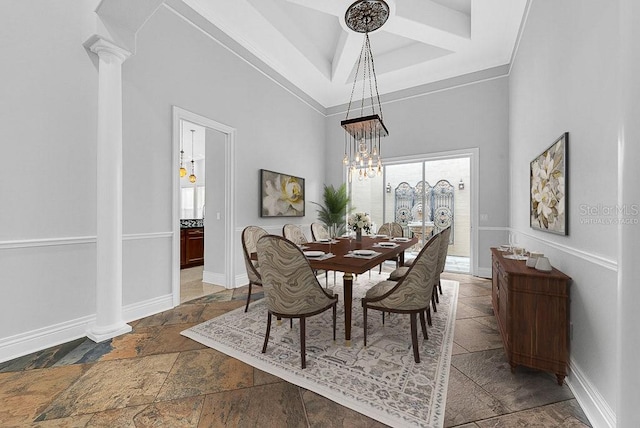 dining space featuring a tray ceiling, a high ceiling, an inviting chandelier, crown molding, and ornate columns