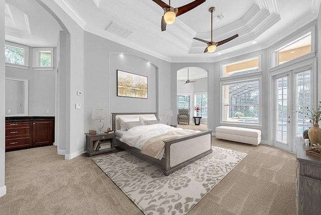 bedroom featuring multiple windows, a tray ceiling, ceiling fan, and access to exterior