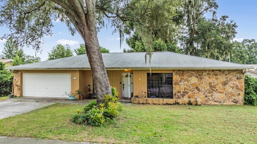 single story home with a garage and a front lawn