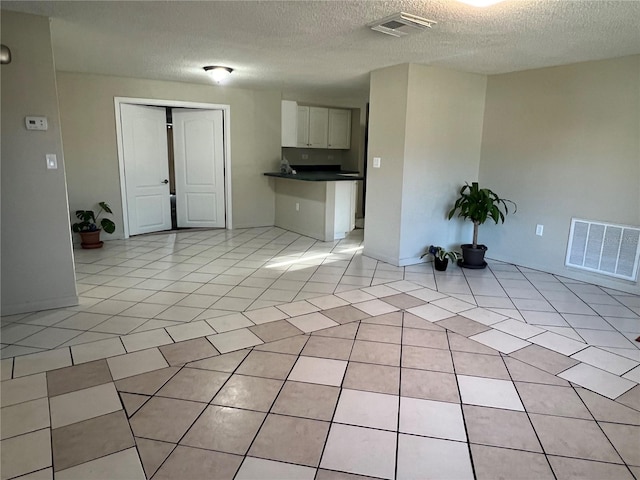 interior space featuring light tile patterned floors and a textured ceiling