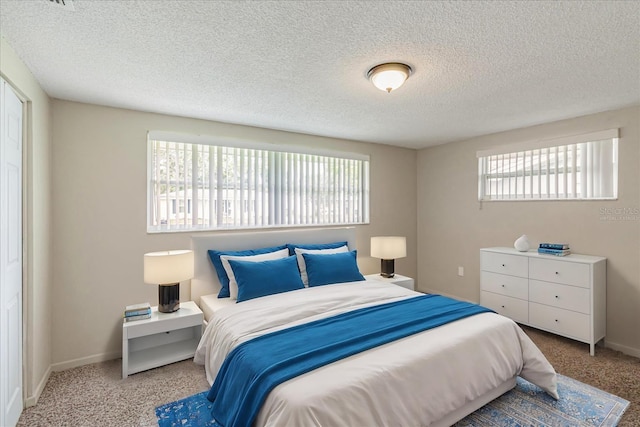 carpeted bedroom featuring a textured ceiling