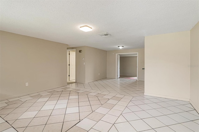 tiled spare room featuring a textured ceiling