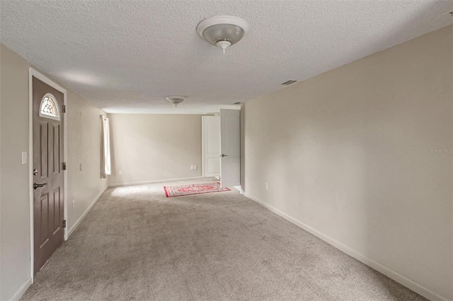 carpeted spare room featuring a textured ceiling