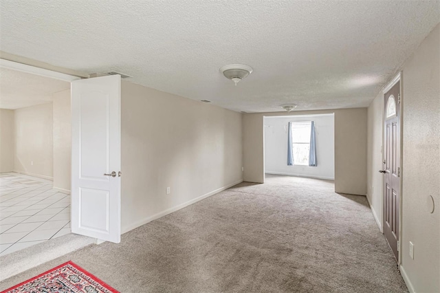 unfurnished room with light carpet and a textured ceiling